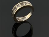 gros plan d'une bague en or avec des diamants sur une surface noire