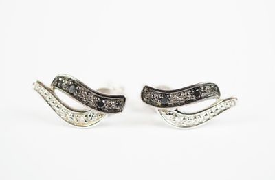 a pair of black and white diamond earrings sitting on top of each other