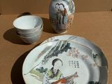 a picture of a table with a plate, bowl, and vase
