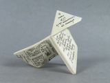 a small origami of a paper boat with writing on it