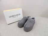 grey sued slippers in front of a white box and a box of shoes