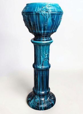 a blue glass vase with a decorative design on the base
