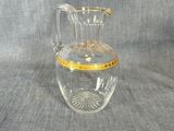 un pichet en verre transparent orné d'un bord doré
