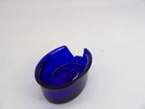 a blue glass ashtray on a white table