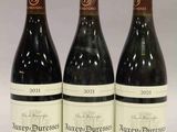 trois bouteilles de vin posées sur une table l'une à côté de l'autre