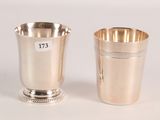 two silver cups with numbers on them sitting next to each other