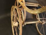 an old fashioned baby carriage with a blanket on it
