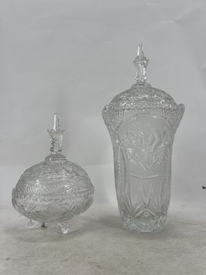 two clear glass vases and a small glass container on a white surface