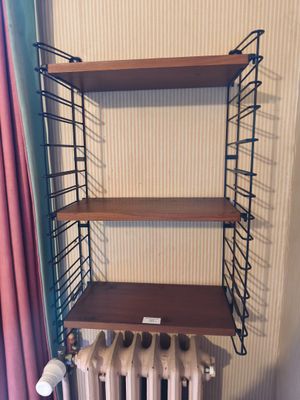 un radiateur et une étagère dans un coin de la pièce