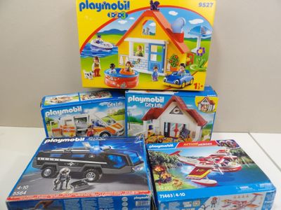 quatre boîtes de Playmobil et une boîte de jouets
