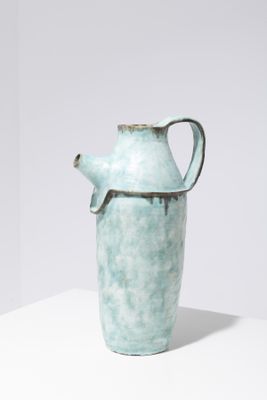 a blue vase that is sitting on a white table