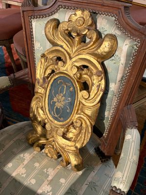 une chaise avec un cadre doré, dans une pièce