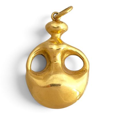 an image of a gold plated pendant with a face on it