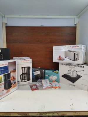 de nombreux cartons contenant des appareils électroménagers posés sur un plan de travail
