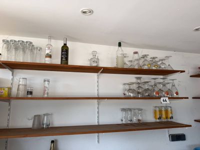 many glasses and bottles on the shelves in the kitchen