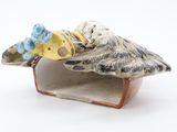 a figurine of a bird with a flower in its beak