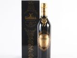 a bottle of black wine next to a box on a white surface