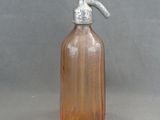 a small glass bottle with a metal handle on a table