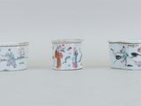 trois tasses ornées de motifs représentant des personnes assises les unes à côté des autres