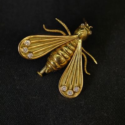 broche en or jaune en forme d'abeille, sertie de diamants, sur fond noir