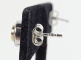 a close up of a pair of silver earrings with black velvet