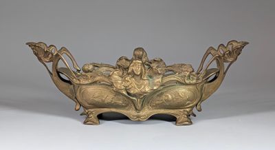 bronze bowl with figures on it on a white surface