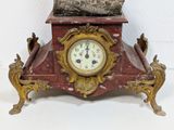 a statue of a man sitting on top of a clock