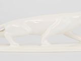 figurine en porcelaine représentant un lion sur un socle blanc