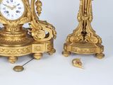 two golden clocks sitting next to each other on a table