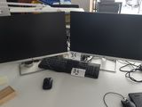 deux écrans d'ordinateur posés sur un bureau à côté d'un ordinateur portable
