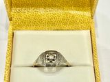 une image représentant une bague dans un écrin posé sur une surface blanche