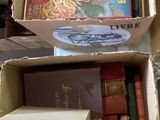Des cartons remplis de livres sont empilés les uns sur les autres sur une table