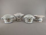 quatre pièces de poterie en porcelaine posées sur une table