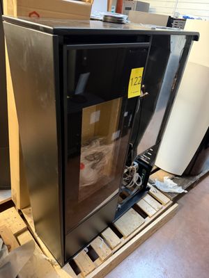 a black refrigerator sitting on top of a pallet in a warehouse