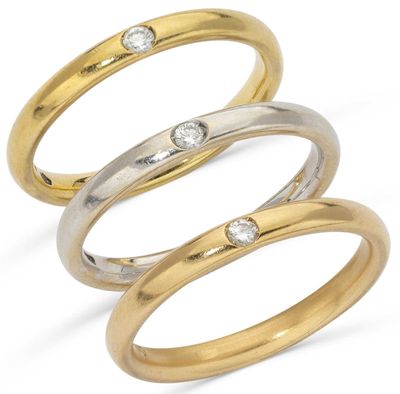 three gold and silver rings with diamonds on a white background
