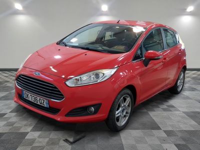 une Ford Fiesta rouge garée dans un garage au sol carrelé