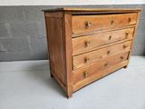 a small wooden chest of drawers on the floor