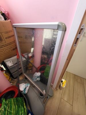 a mirror that is sitting on the floor next to a trash can