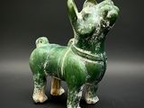 a green statue of a dog on a black background