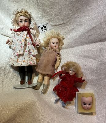 three dolls sitting next to each other on a white cloth