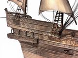 a metal model of a ship on a white surface