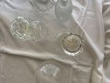 a white sheet on the bed with a bottle of water and glassware