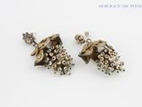 pair of earrings with pearls and pearls on them on a white surface