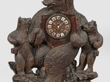 une horloge en bois sur laquelle figurent un ours et deux chats