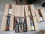 several bottles of wine are in a cardboard box on the floor