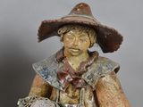 a figurine of a man with a hat and a dog