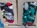 two boxes with clothes and shoes in them on the floor