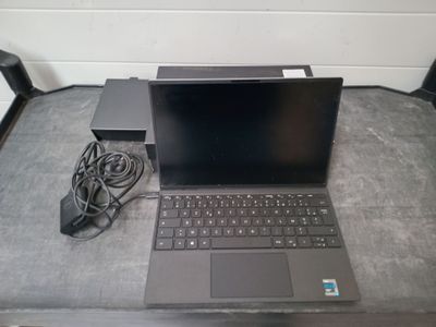 un ordinateur portable posé sur une table avec un chargeur