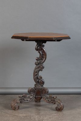 une vieille table en bois avec un plateau sculpté et un piètement en bois