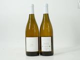 two bottles of wine sitting next to each other on a table